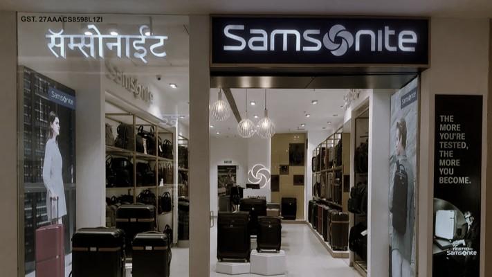 Boutique retail store featuring high-end handbags on wall-mounted displays, minimalistic decor, and soft overhead lighting